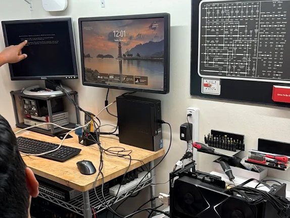 Prime Bridge repair bench with two monitors, a desktop computer, a graphics card and organized tool racks